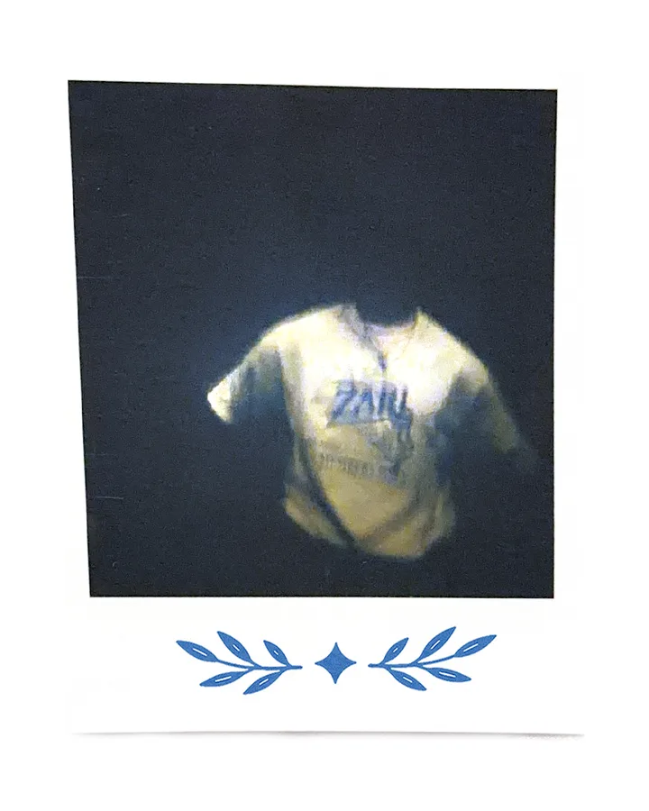 A Zari tee lit against black, floating like a ghost.