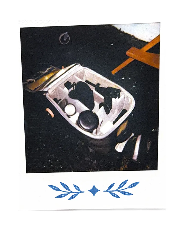 An open car console, tools and cups tipped inside.